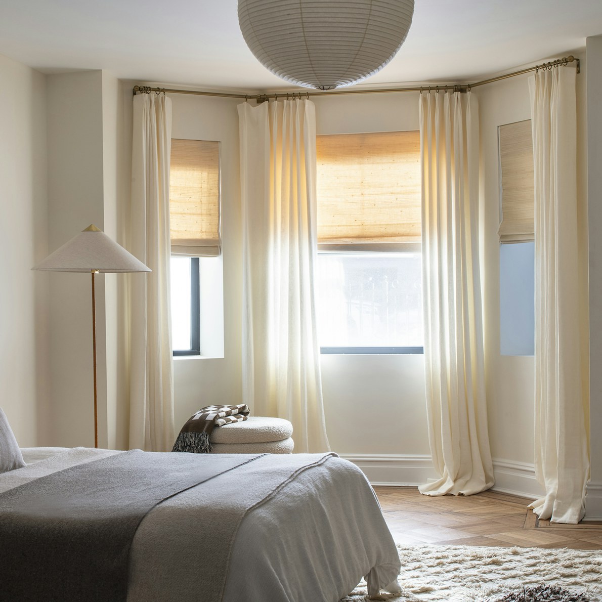 Luxury curtain rods with pinch pleat drapes in a bedroom